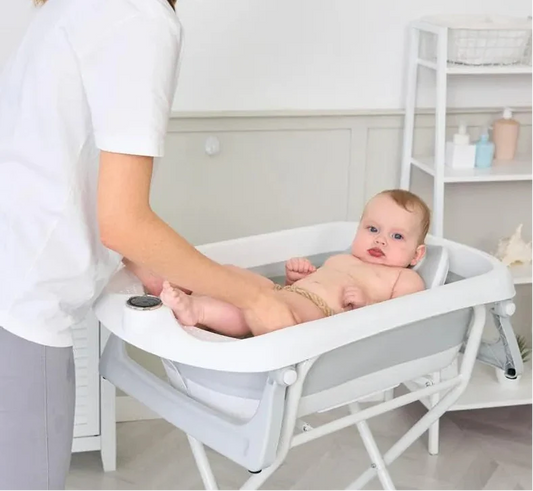 Parent donnant le bain à son bébé en toute sécurité dans une baignoire bébé, avec maintien adapté et gestes rassurants