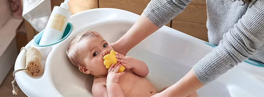 Bain d’un nouveau-né dans une baignoire bébé sécurisée, avec maintien adapté dès la naissance