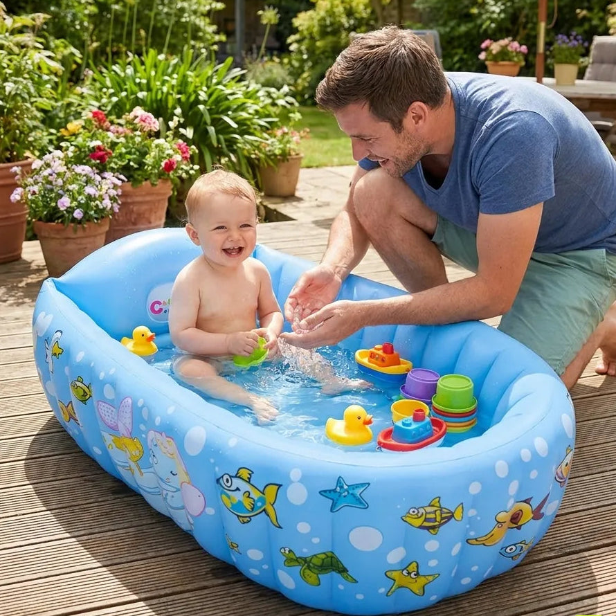 Bebe souriant dans baignoire gonflable bleue avec jouets dans un jardin