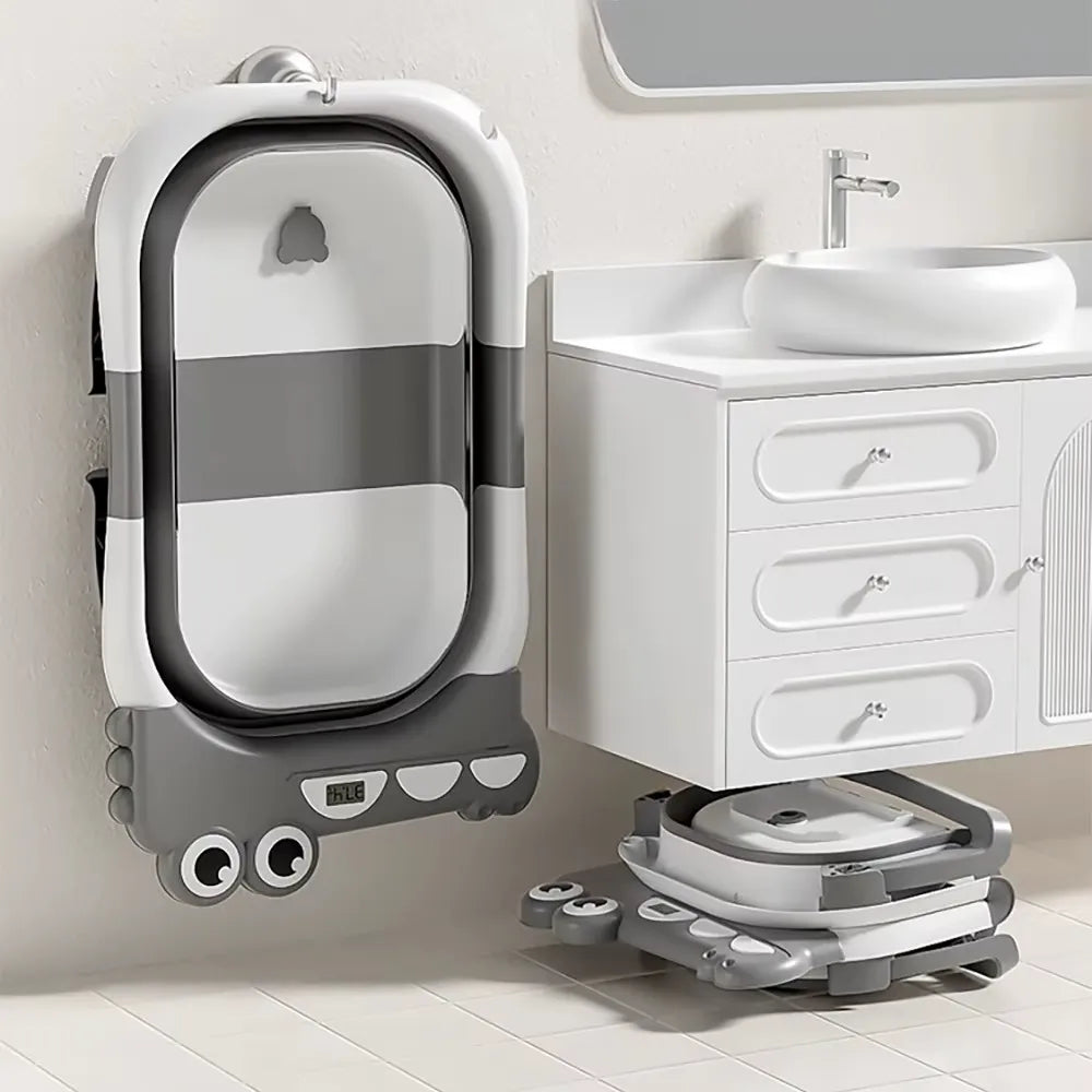 Baignoire bébé pliable grise rangée contre le mur dans une petite salle de bain