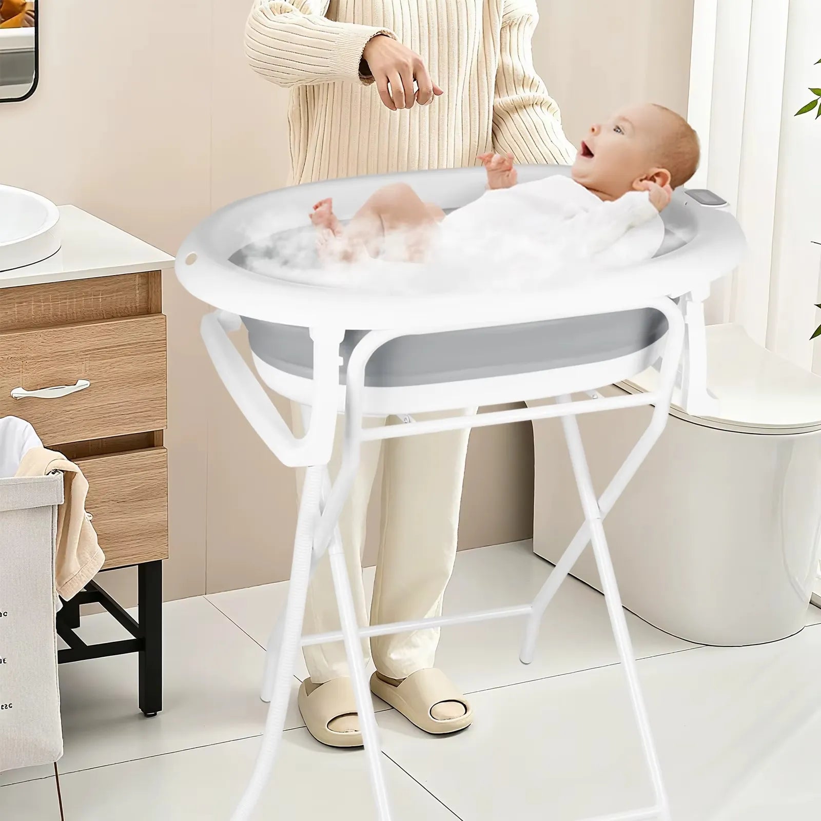 Baignoire bébé sur pied pliable avec transat et thermomètre utilisée dans une salle de bain