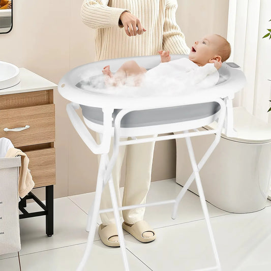 Baignoire bébé sur pied pliable avec transat et thermomètre utilisée dans une salle de bain