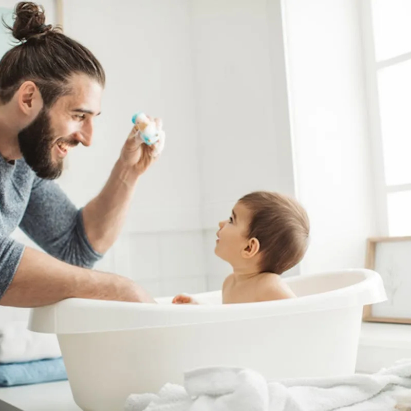 Parent adoptant une posture confortable pendant le bain sécurisé de bébé
