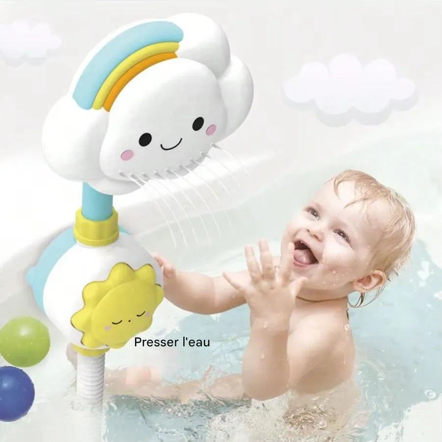 Bébé souriant dans baignoire avec jouet nuage douche arc-en-ciel qui projette l'eau