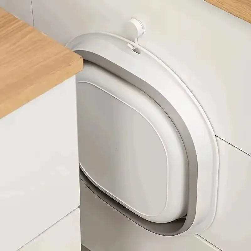 Petite baignoire bébé pliable rangée à plat derrière une porte