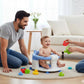 Siège-baignoire enveloppant pour bébé avec protection à 360° pour papa et maman avec bébé dans le salon.