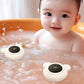 Bébé jouant dans le bain avec deux thermomètre de bain ourson flottant
