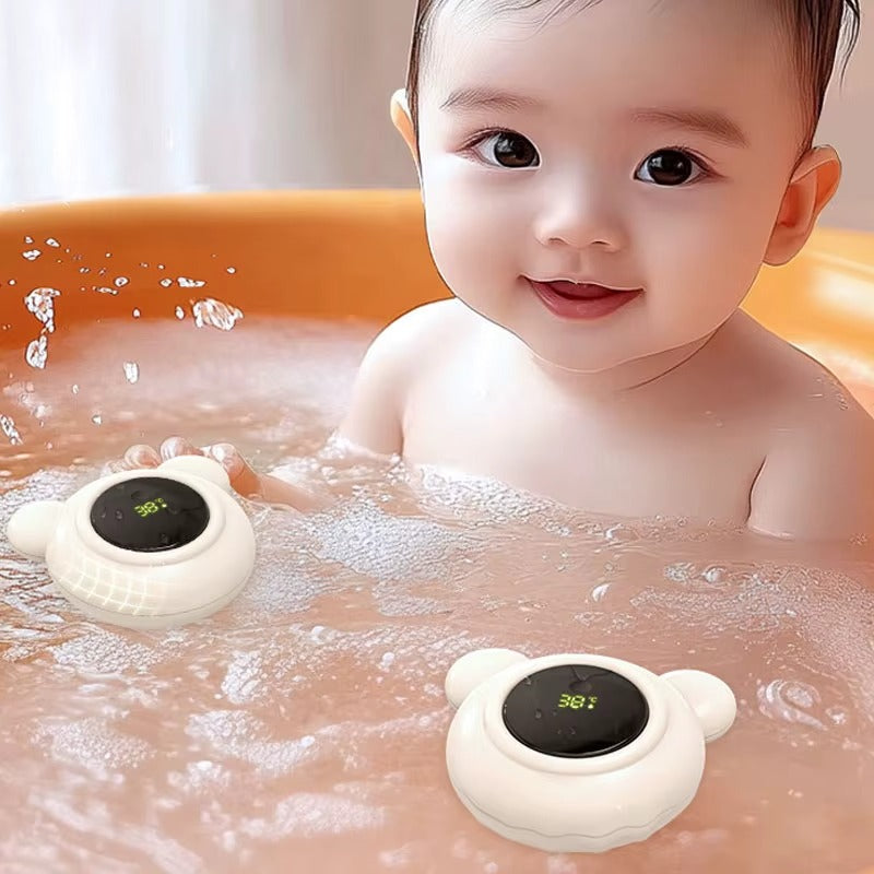 Bébé jouant dans le bain avec deux thermomètre de bain ourson flottant