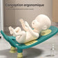 Bébé allongé sur transat de bain ergonomique respectant la position naturelle du dos